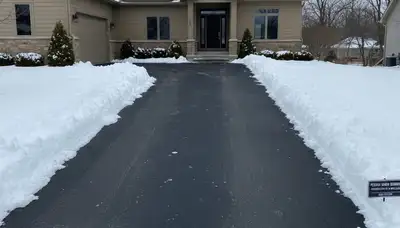 Clean driveway after professional snow removal by Chop Chop Landscaping in Peoria, IL